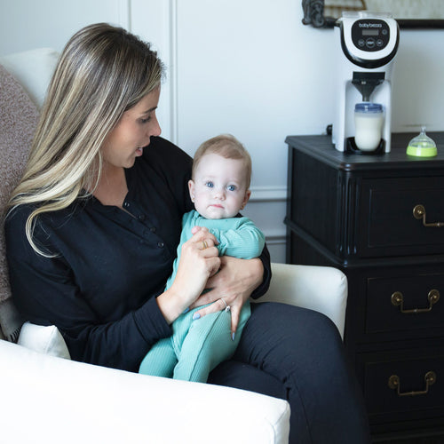 Mother with a child while Baby Brezza Formula Pro Mini dispenses a bottle - product thumbnail