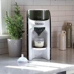 Baby Brezza Formula Pro Advanced dispensing formula into a bottle on a kitchen countertop. - product thumbnail