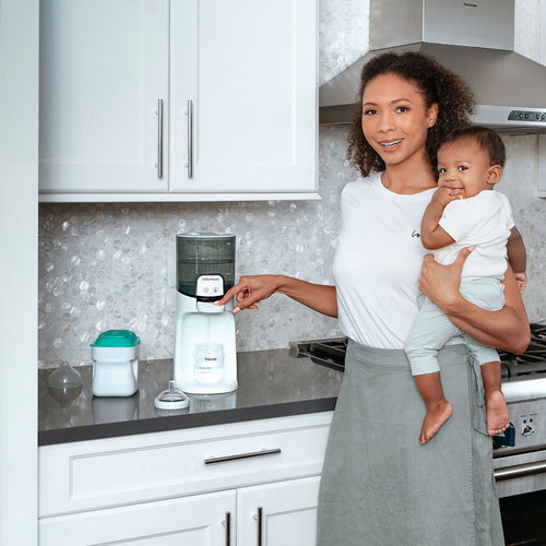 A mother operating Baby Brezza Instant Water Warmer with child  - product thumbnail