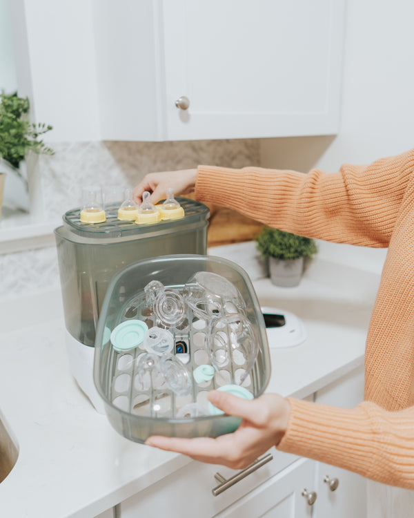 Baby Brezza Sterilizer in use , Small basket with bottle parts in the kitchen - product thumbnail