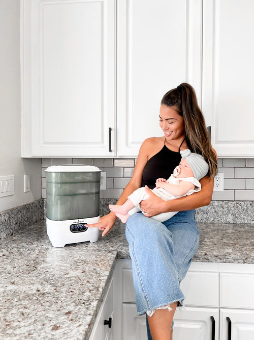 Baby Brezza Sterilizer Dryer in use by a mother with a baby in the kitchen   - product thumbnail